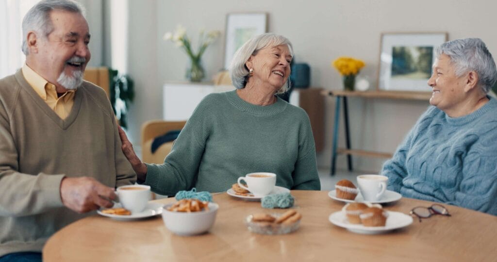 Senioren genießen eine gesellige Kaffeerunde in ihrer Pflegeeinrichtung.